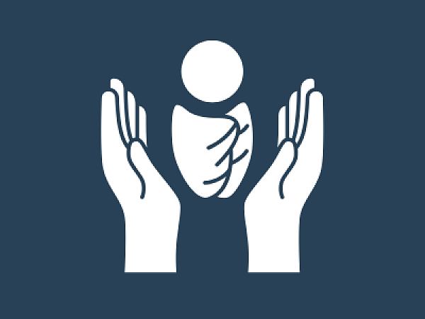 Ein Baby welches schützend von zwei Händen gehalten wird